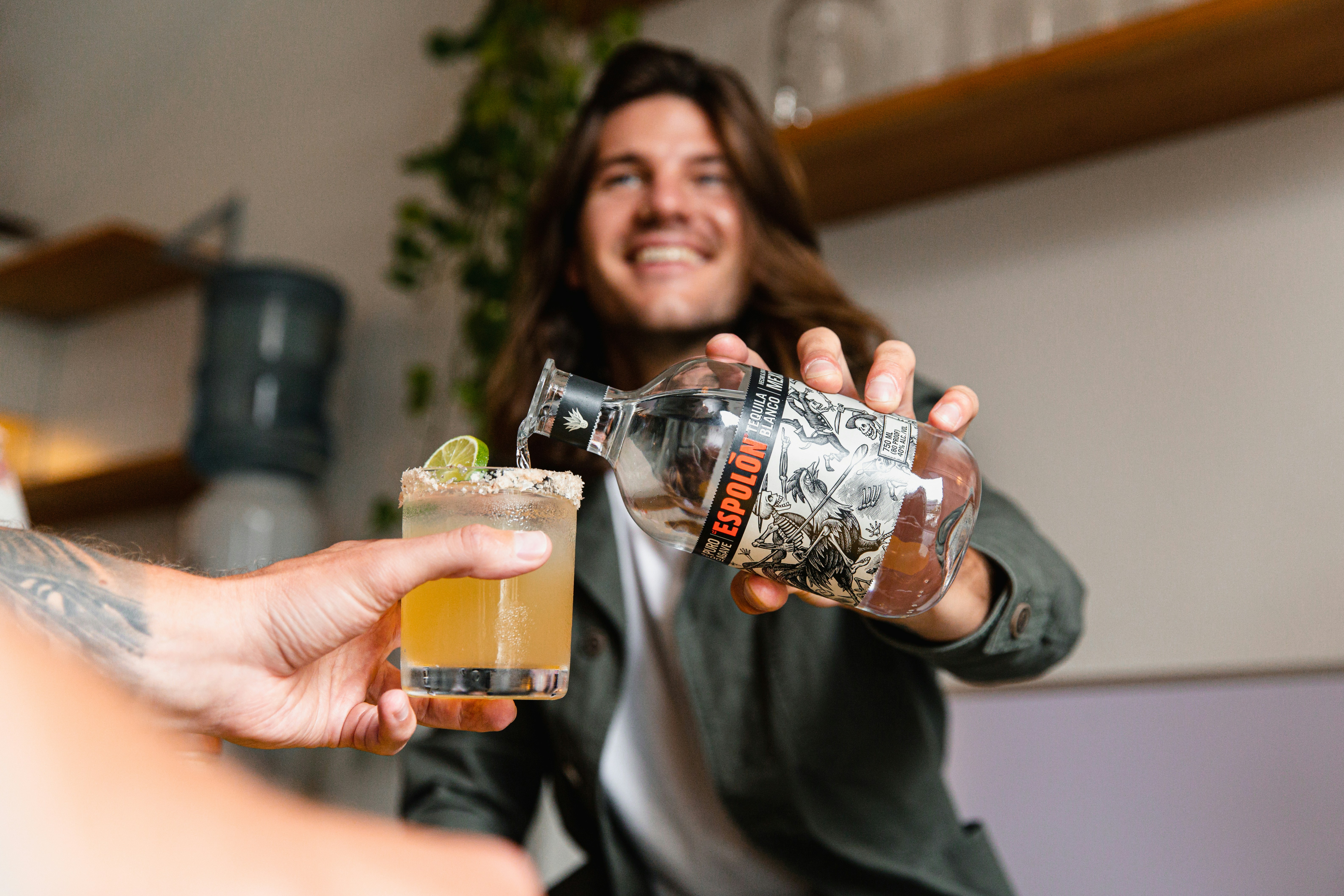 man in gray crew neck shirt holding clear glass bottle