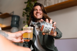 Hands pouring a traditional Mexican spirit into a tasting glass.