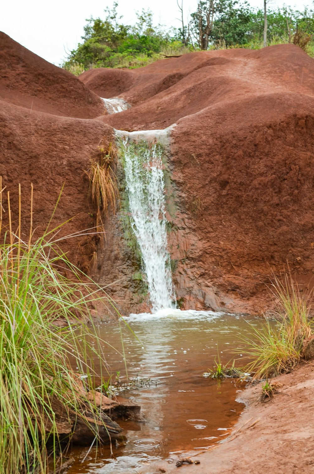 water falls on brown mountain