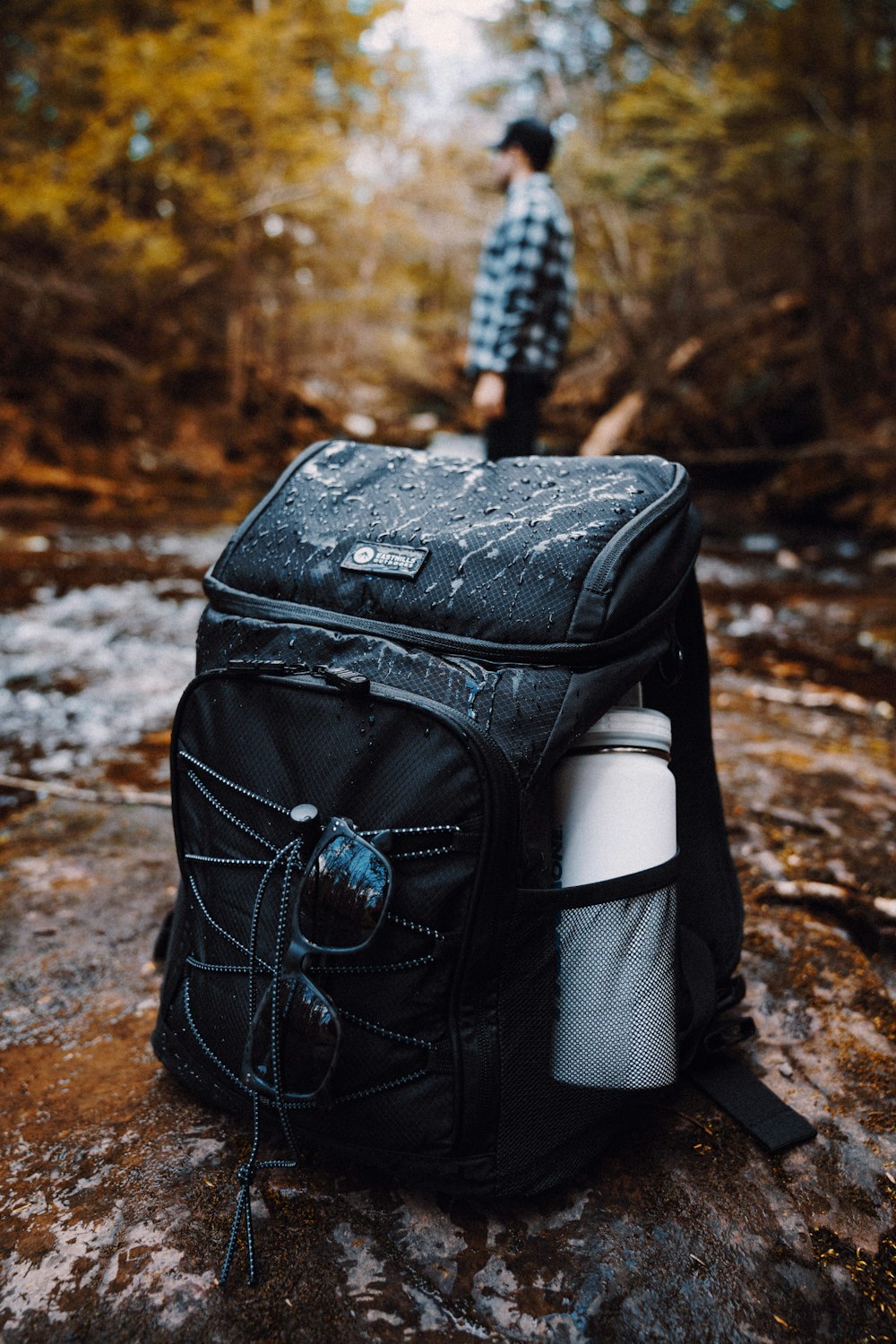 black backpack on brown and white rock