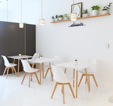 white table and chairs near black wall