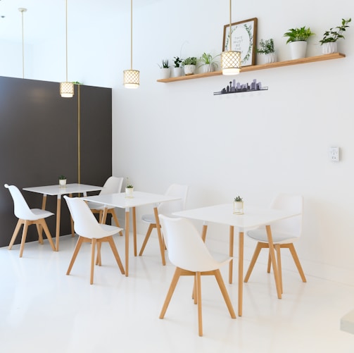 white table and chairs near black wall