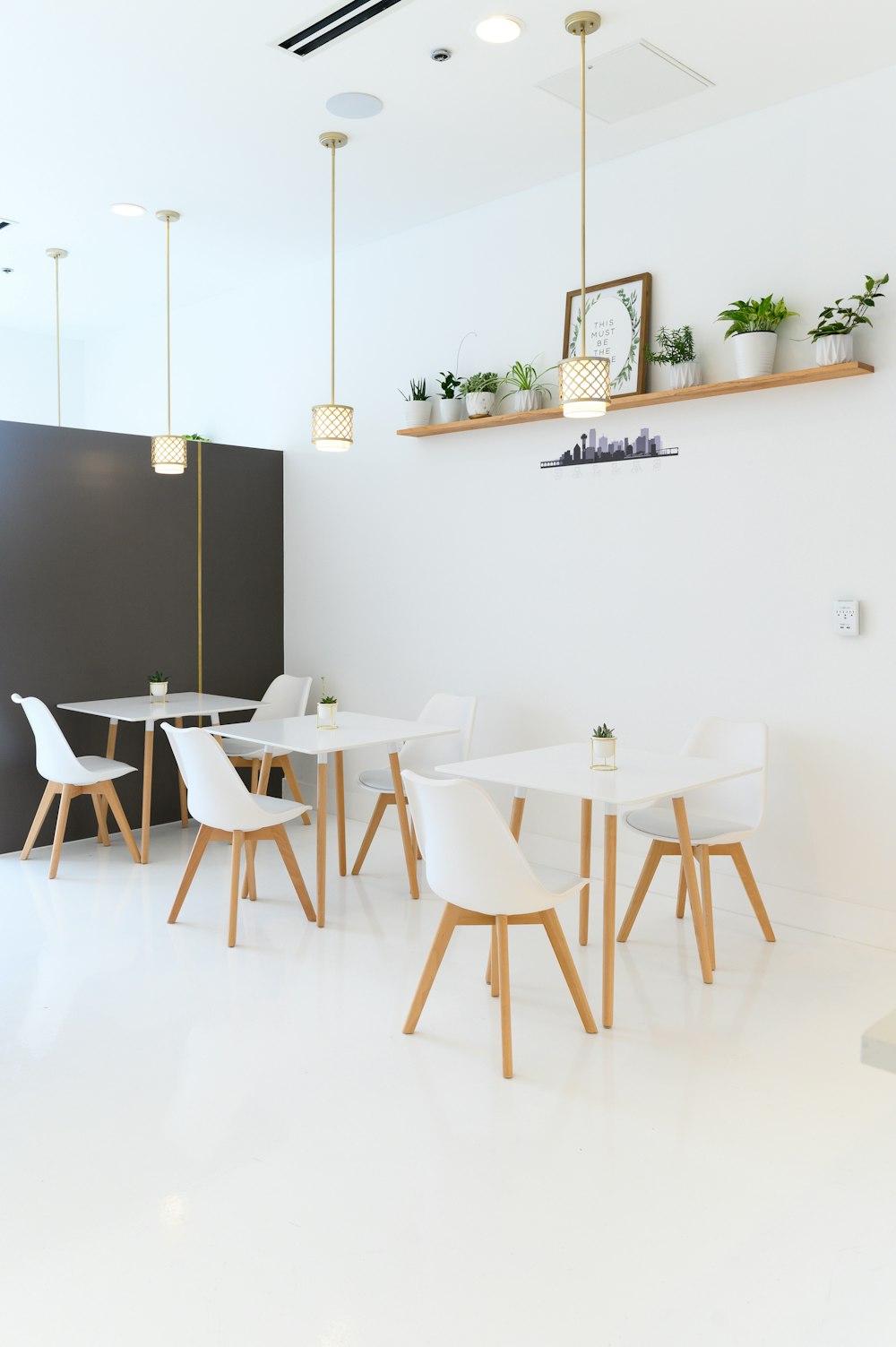 white table and chairs near black wall