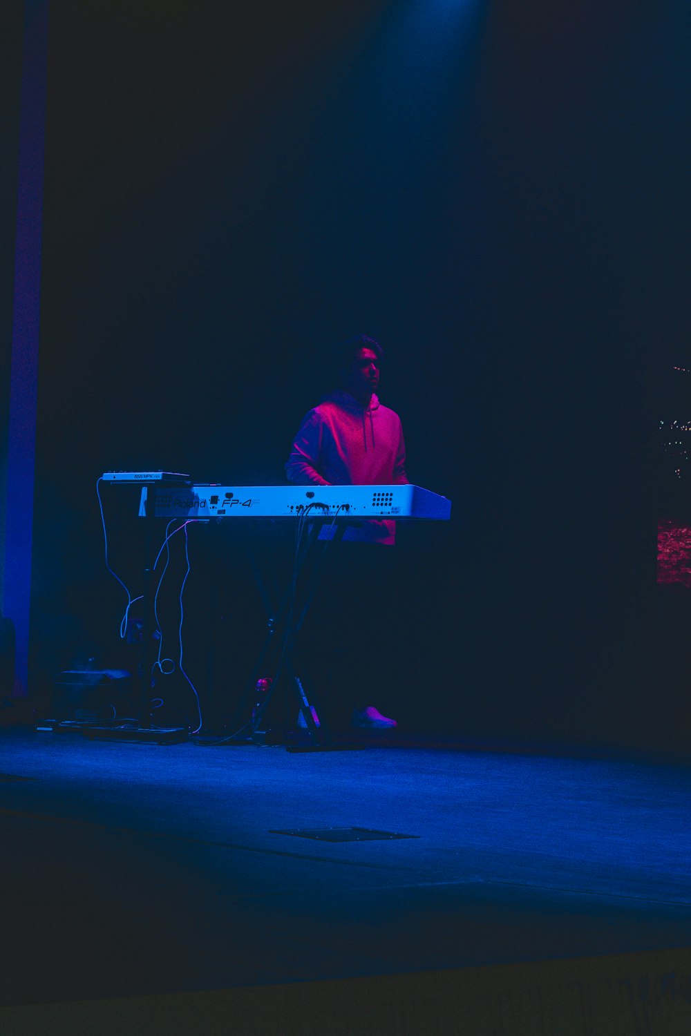 man in red dress shirt playing electric guitar