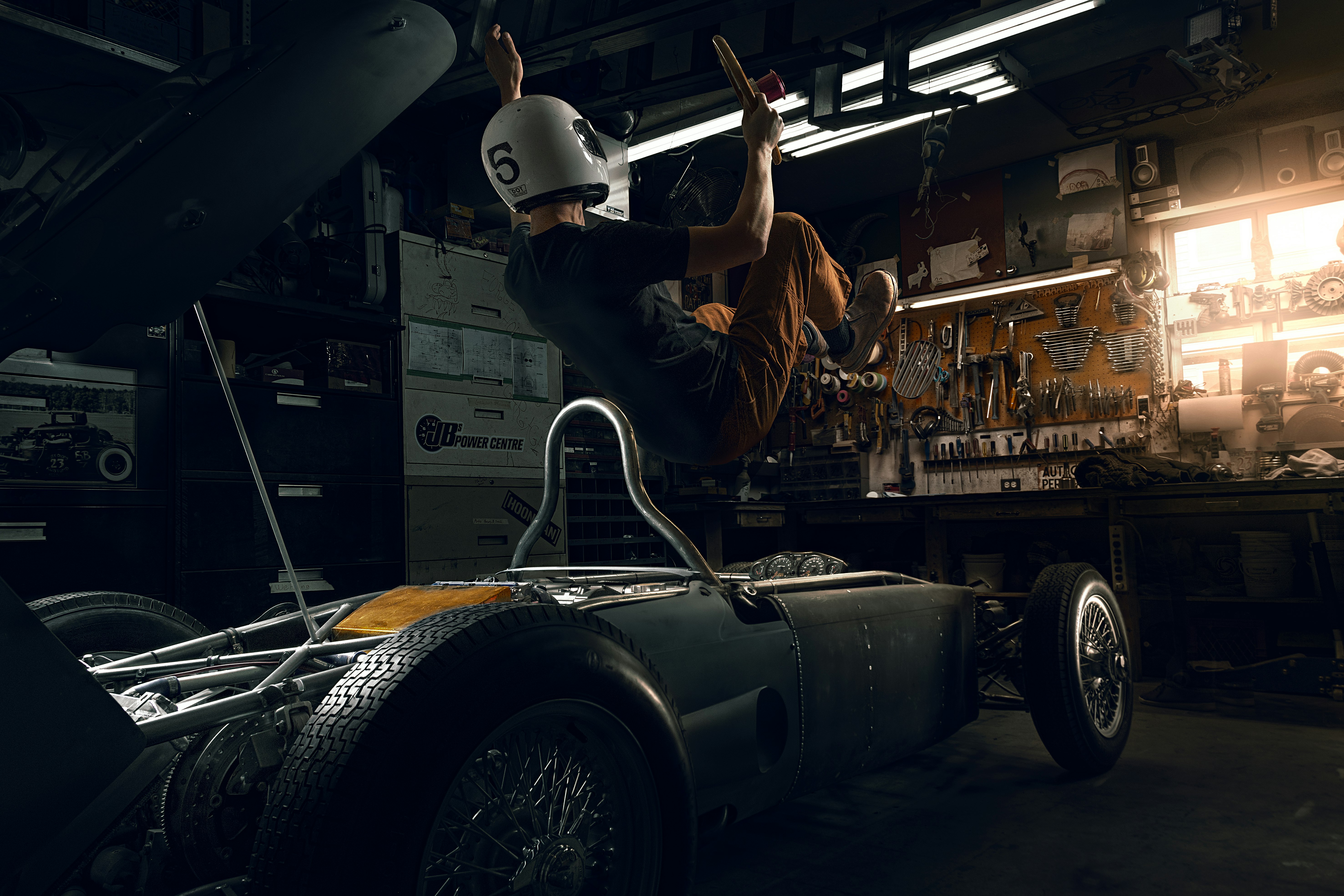 man in brown jacket and white helmet riding on black car