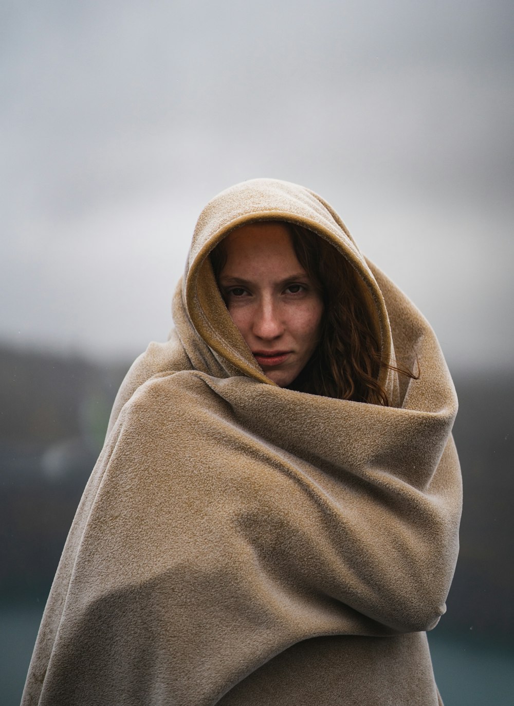 woman in brown hijab covering her face with brown blanket
