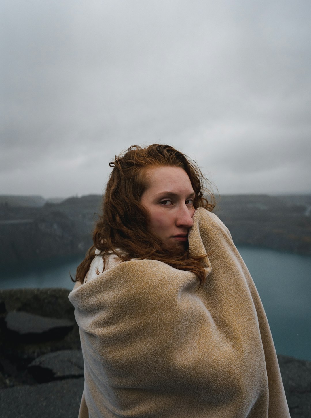 woman in white sweater standing on rock formation during daytime