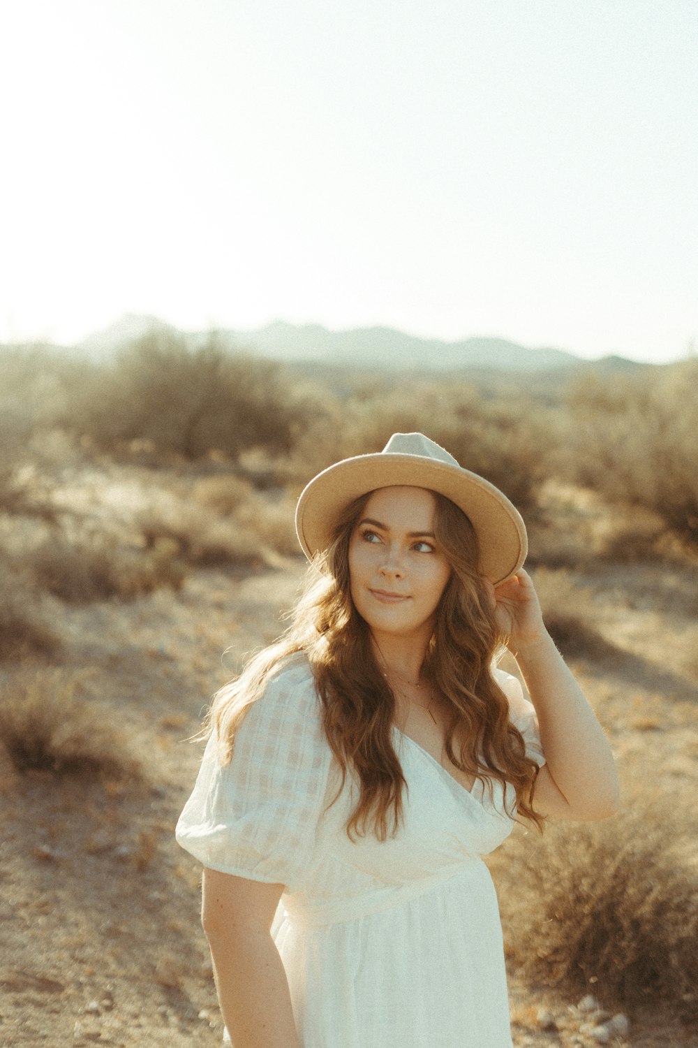 woman in white and brown plaid shirt wearing brown hat