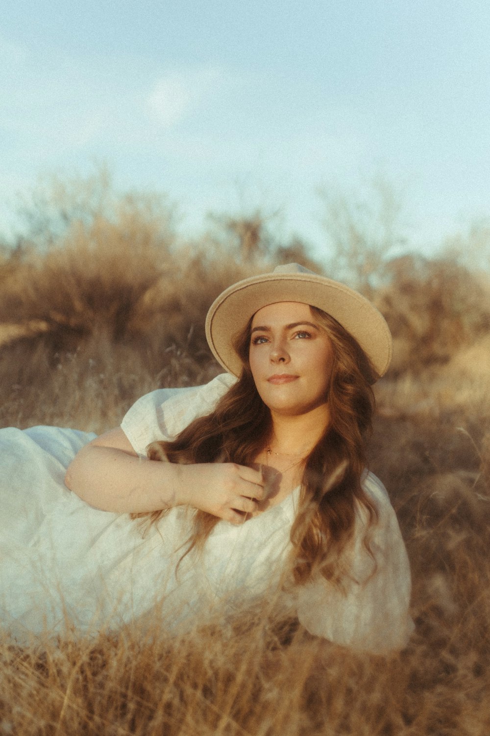 woman in white long sleeve shirt wearing brown hat