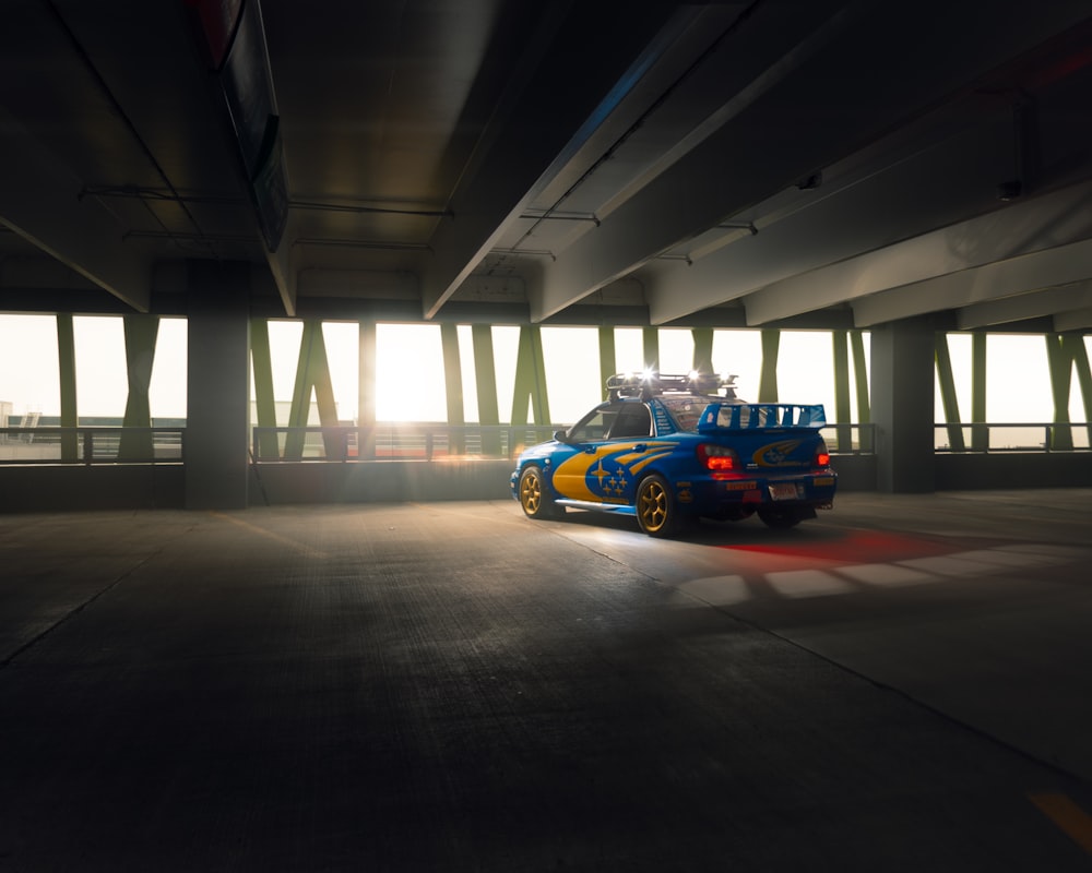 orange and blue sports car on gray concrete floor