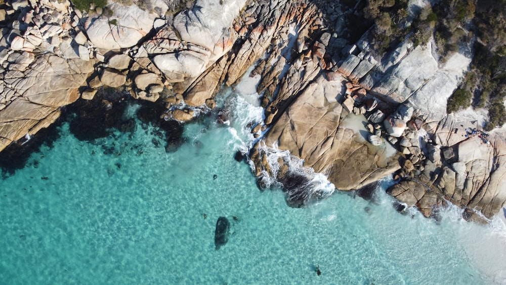 brown rock formation on body of water during daytime