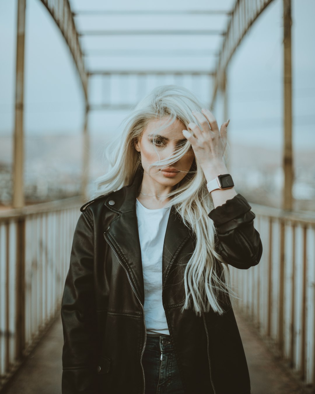 woman in black leather jacket covering her face