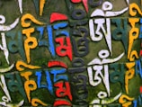 Close-up of a hand-painted Tibetan thangka with vibrant mineral colors.