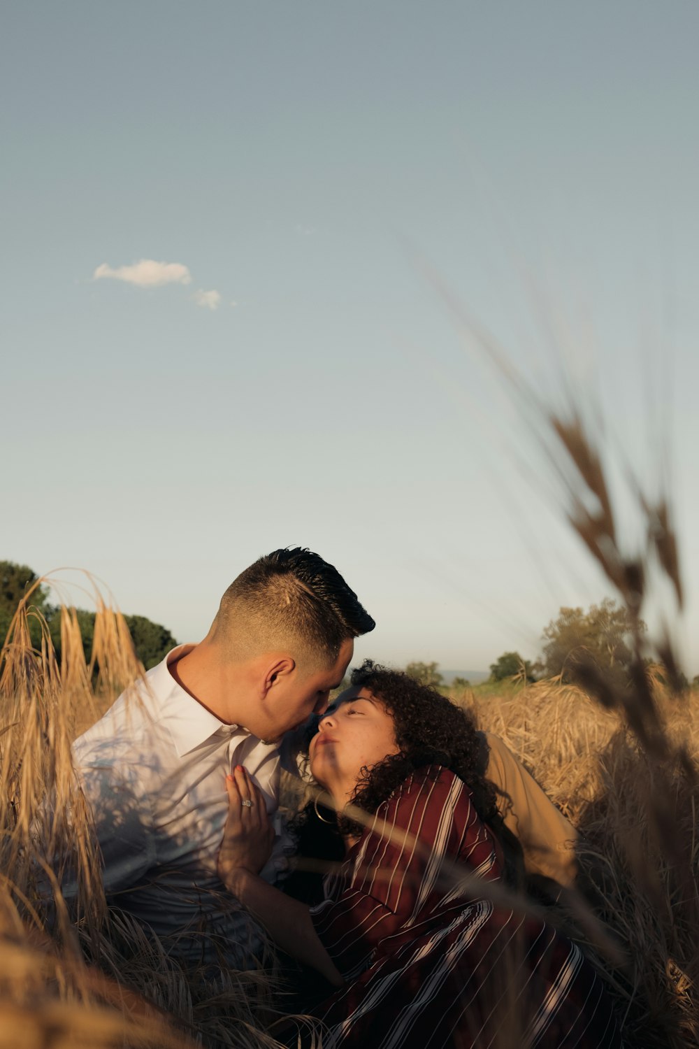 man in blue and white plaid button up shirt standing on brown grass field during daytime