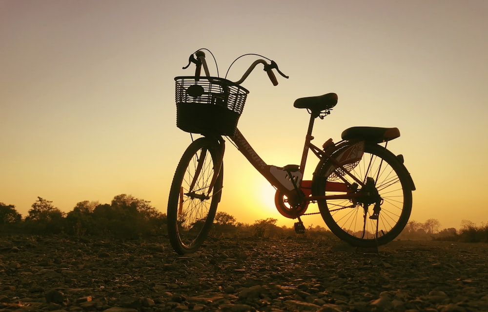 black and brown bicycle on brown field during sunset