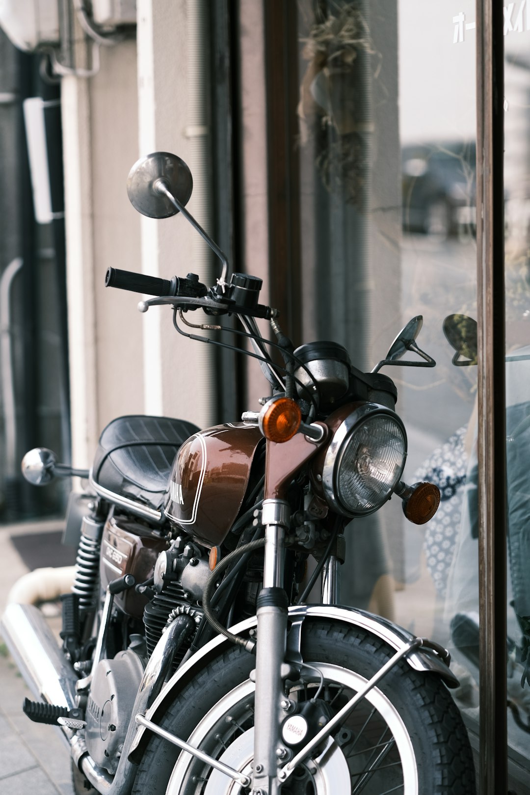 black and brown motorcycle parked beside glass window