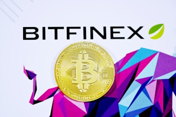 A golden Bitcoin coin is placed against a background with the word 'Bitfinex' in bold black letters and a geometric pattern of multicolored shapes. The Bitcoin symbol is prominently centered in the metallic coin.
