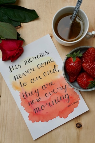 A colorful flat lay of fresh fruits, a journal, and a cup of herbal tea on a wooden table.