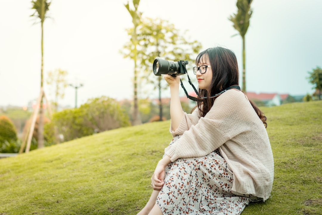 woman in white lace dress holding black dslr camera