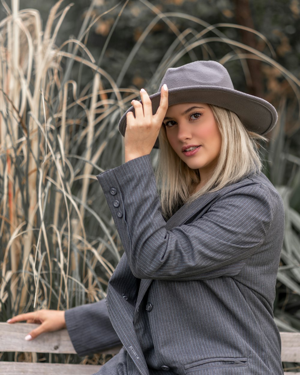 woman in gray coat and black fedora hat