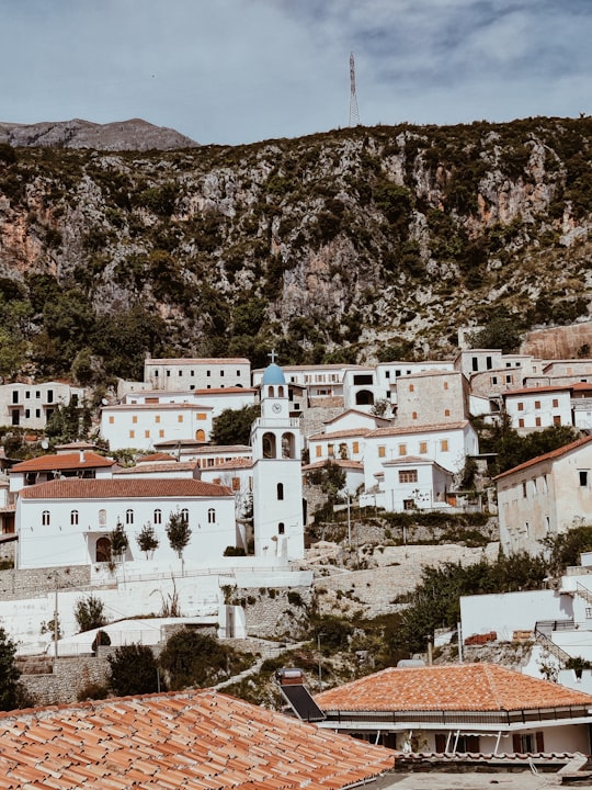 white and brown concrete buildings on brown rocky mountain during daytime in Dhërmi Albania