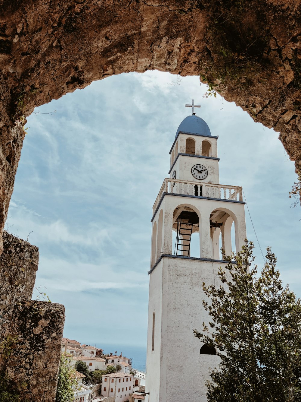 Edificio in cemento bianco e blu sotto nuvole bianche durante il giorno