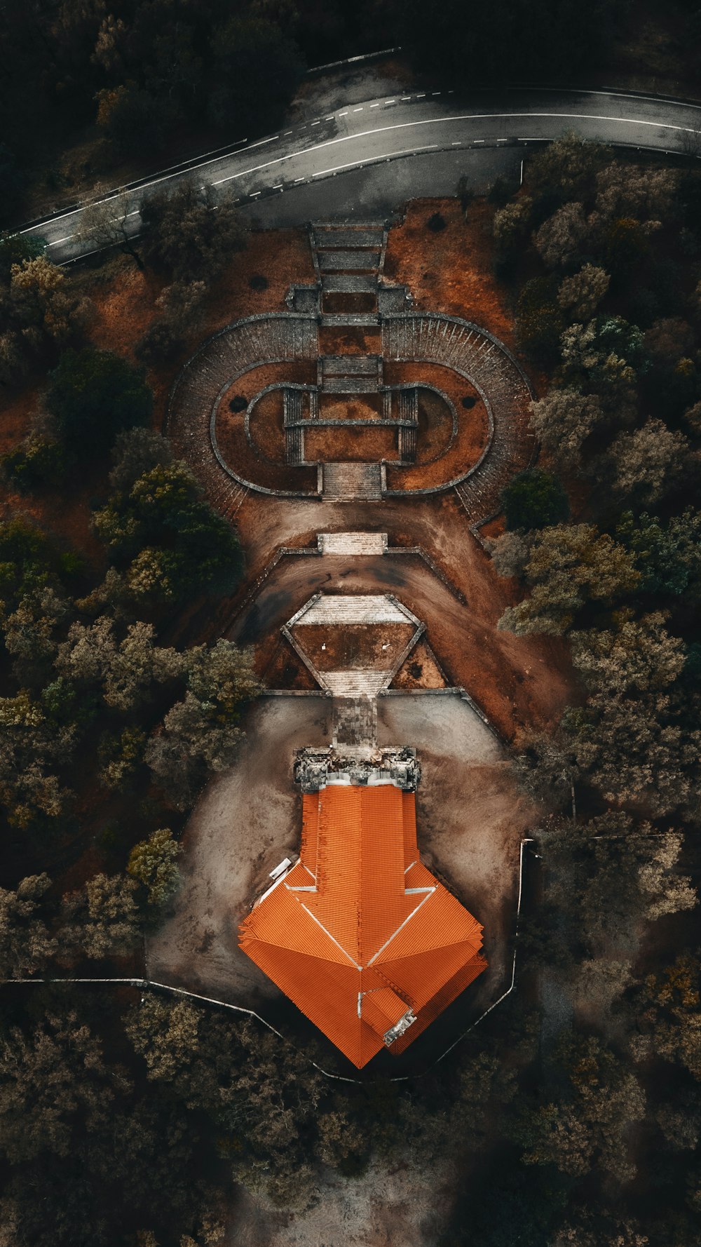 aerial view of orange and brown cross in the middle of forest
