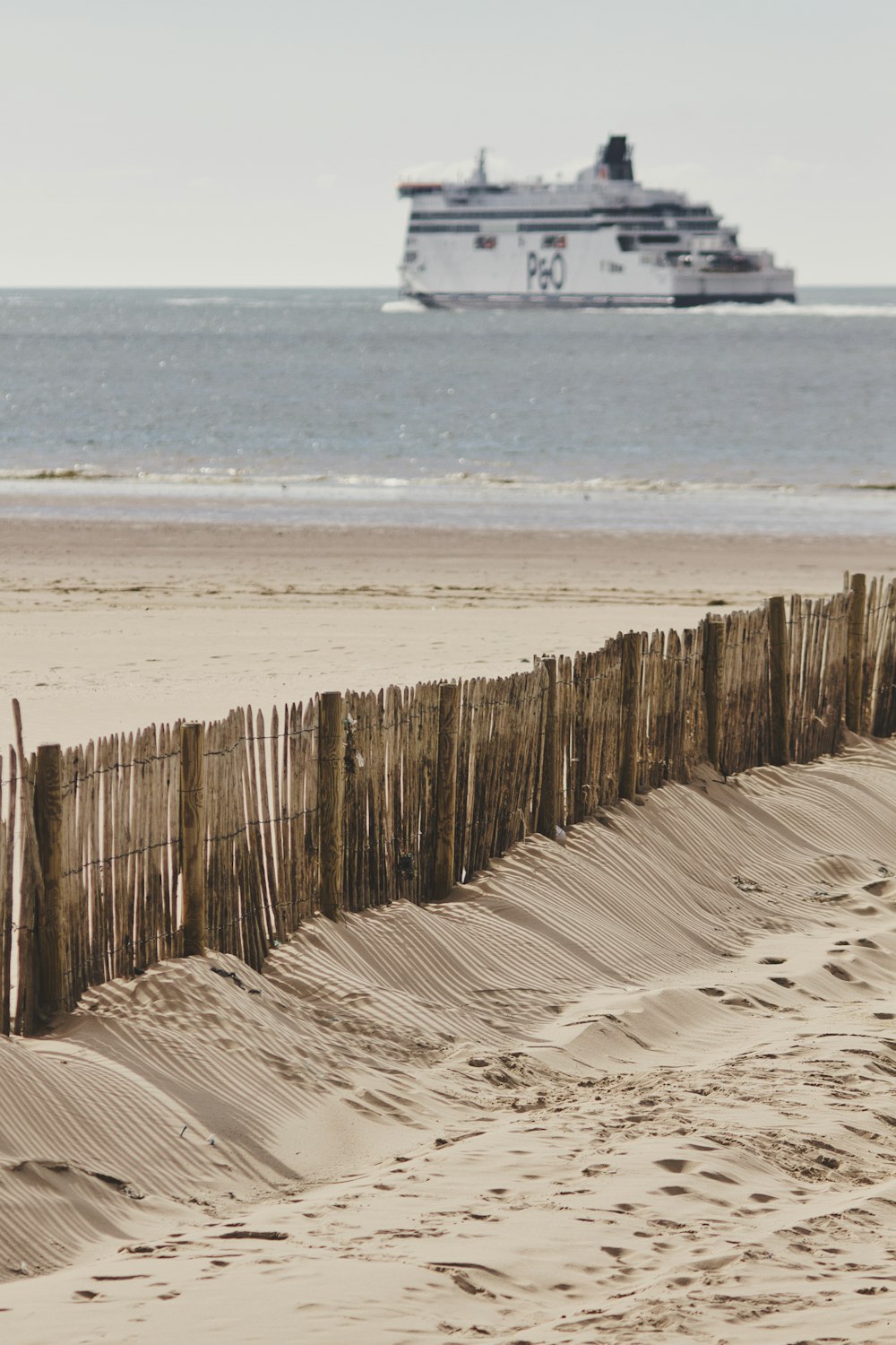 brown wooden fence on beach during daytime