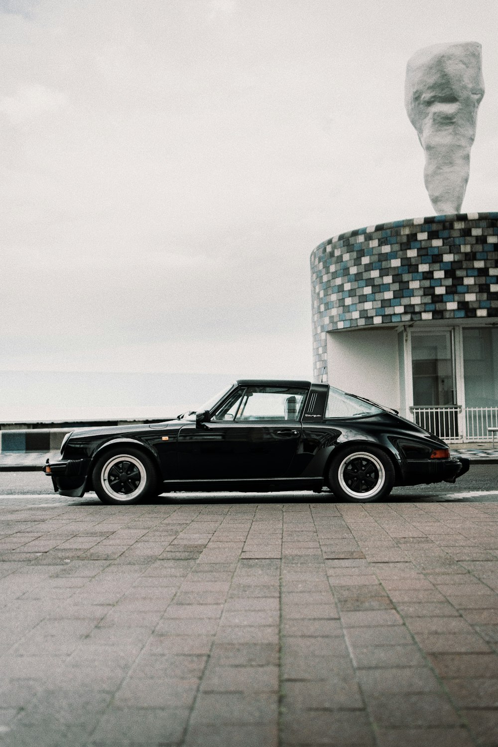 cupê preto estacionado ao lado do edifício branco