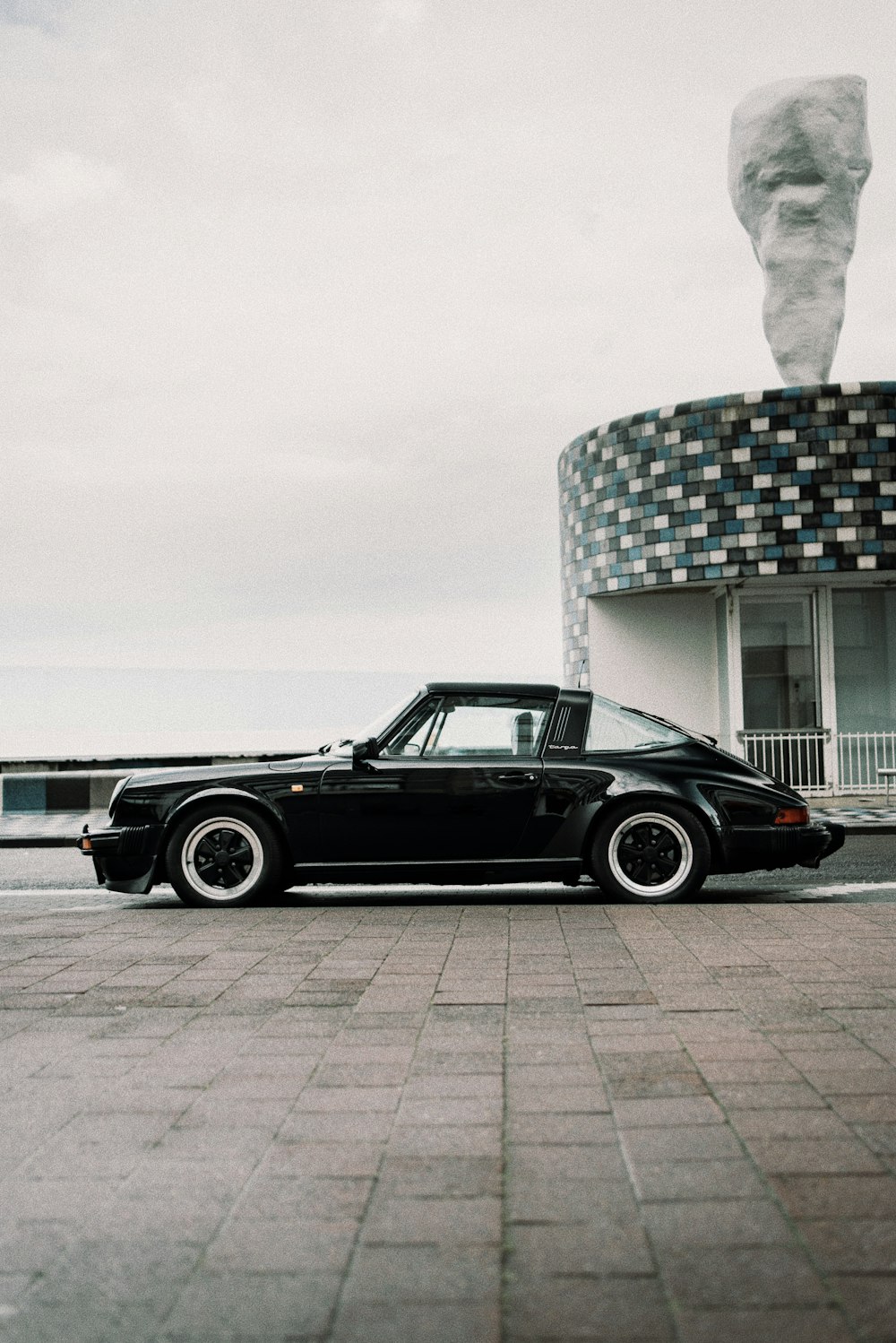 black coupe parked beside white building