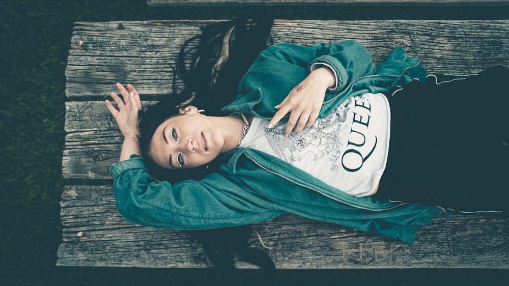 woman in blue denim jacket lying on wooden floor