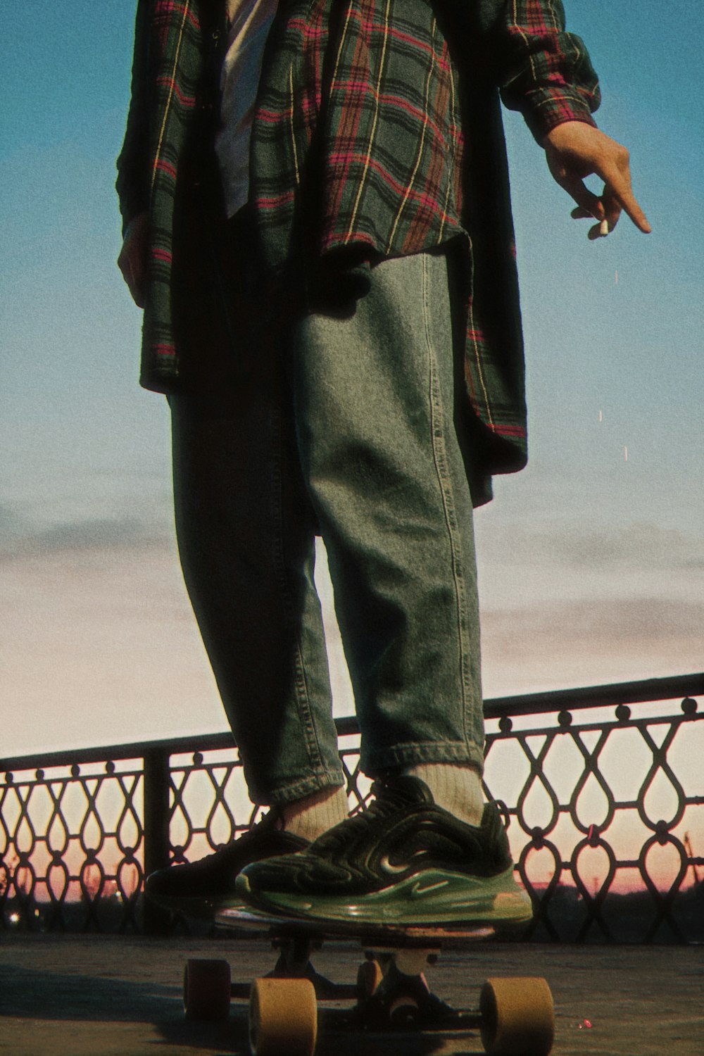 person in black denim jeans standing near black metal fence during daytime