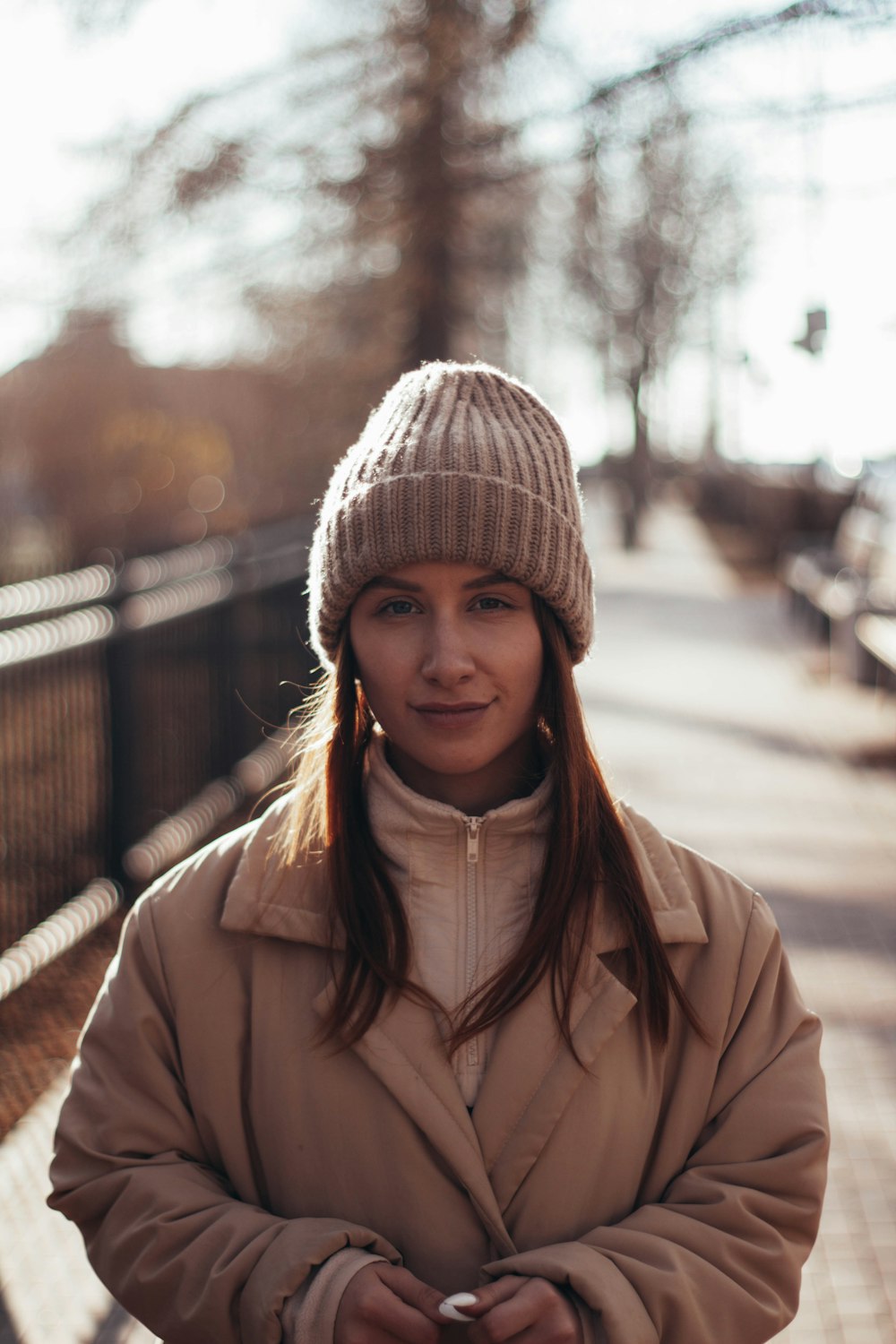 woman in brown coat wearing gray knit cap