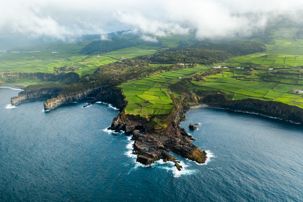 aerial view of green grass field near body of water during daytime