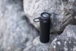 Close-up of the 7L hydration bottle with volcanic rocks in the background.