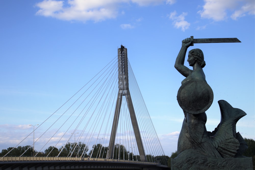 statue of man on top of a bridge