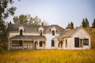 white and brown house near green grass field during daytime