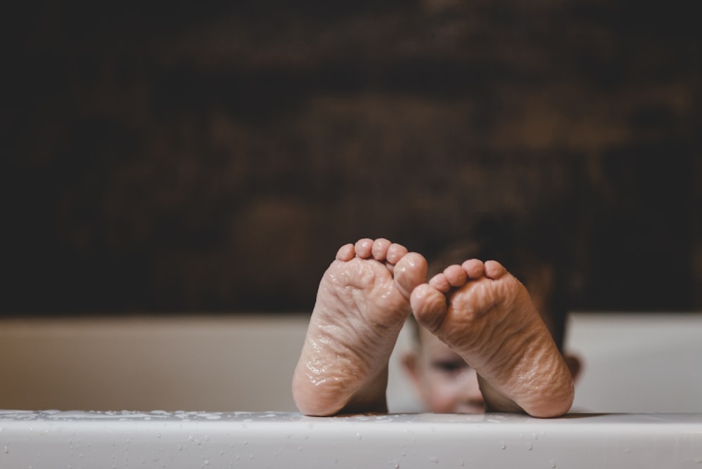 persons feet on white surface