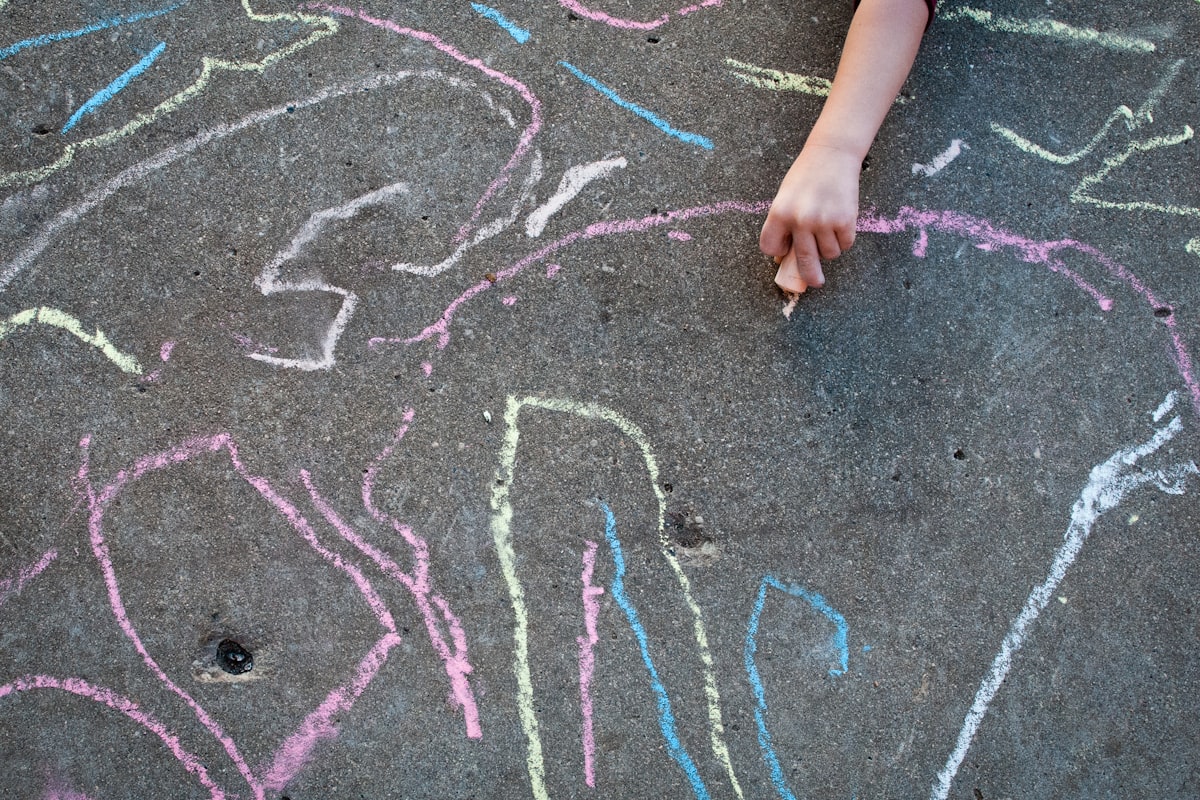 A child drawing with sidewalk chalk