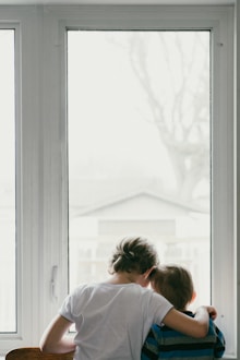 Mujer mirando por una ventana, en reflexión