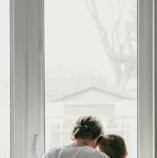 woman in white shirt looking at the window