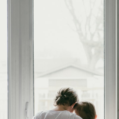 woman in white shirt looking at the window