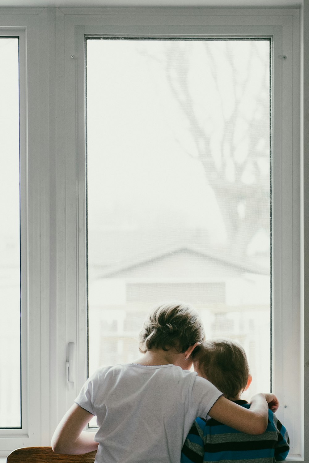 Mujer con camisa blanca mirando a la ventana