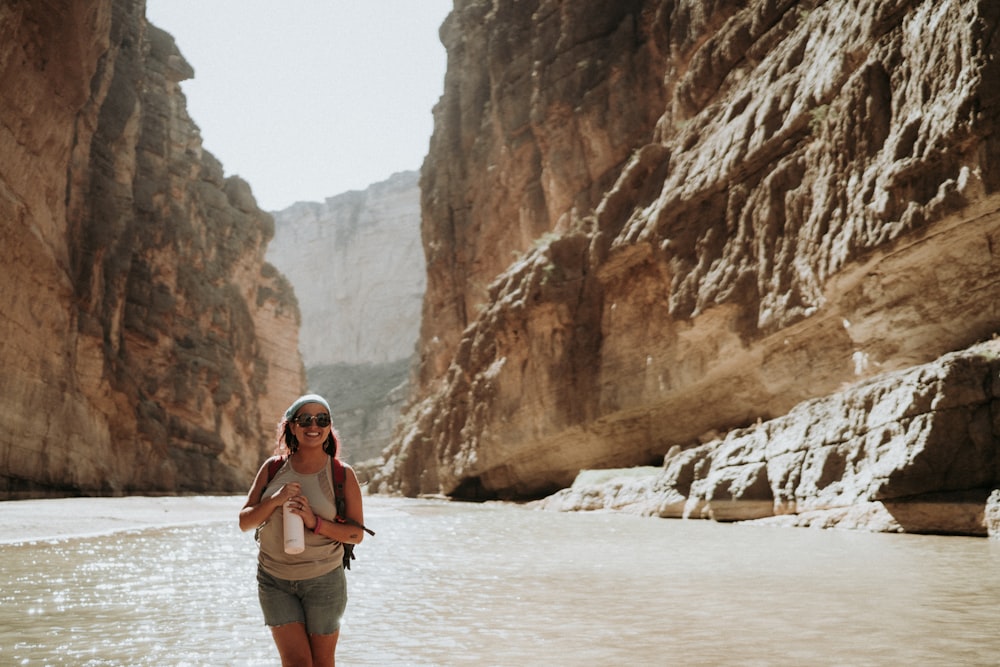 woman in white bikini standing on body of water during daytime