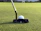 Close-up of a golfer using a sleek golf rangefinder device during a game.