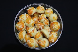 A delighted customer holding a plate of bolinha de queijo with goiabada.