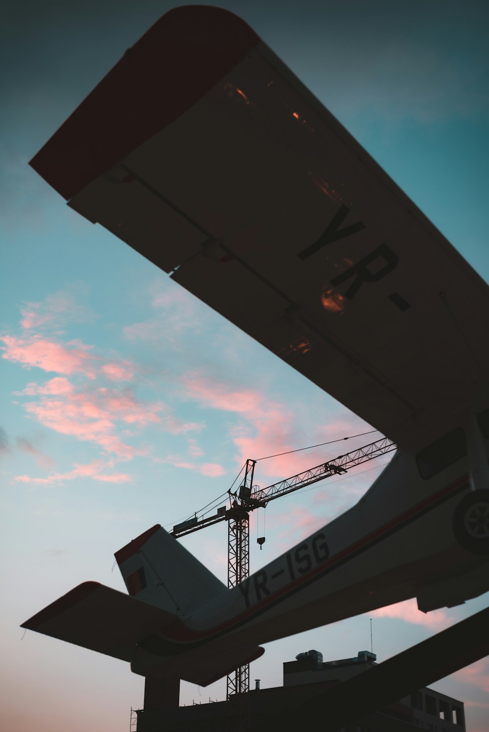 silhouette of crane under cloudy sky during daytime