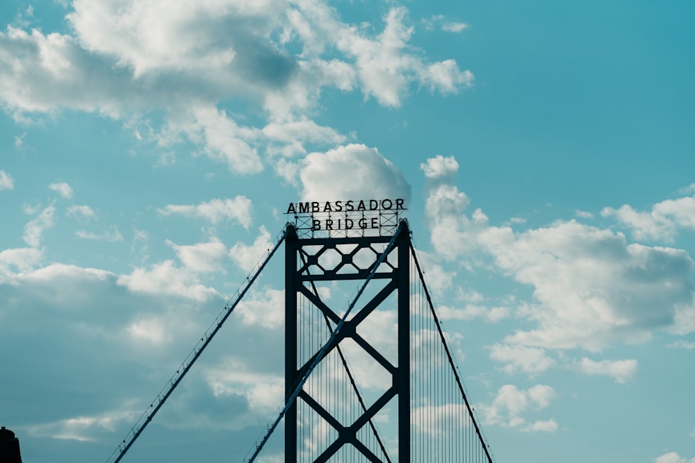 gray bridge under white clouds and blue sky during daytime