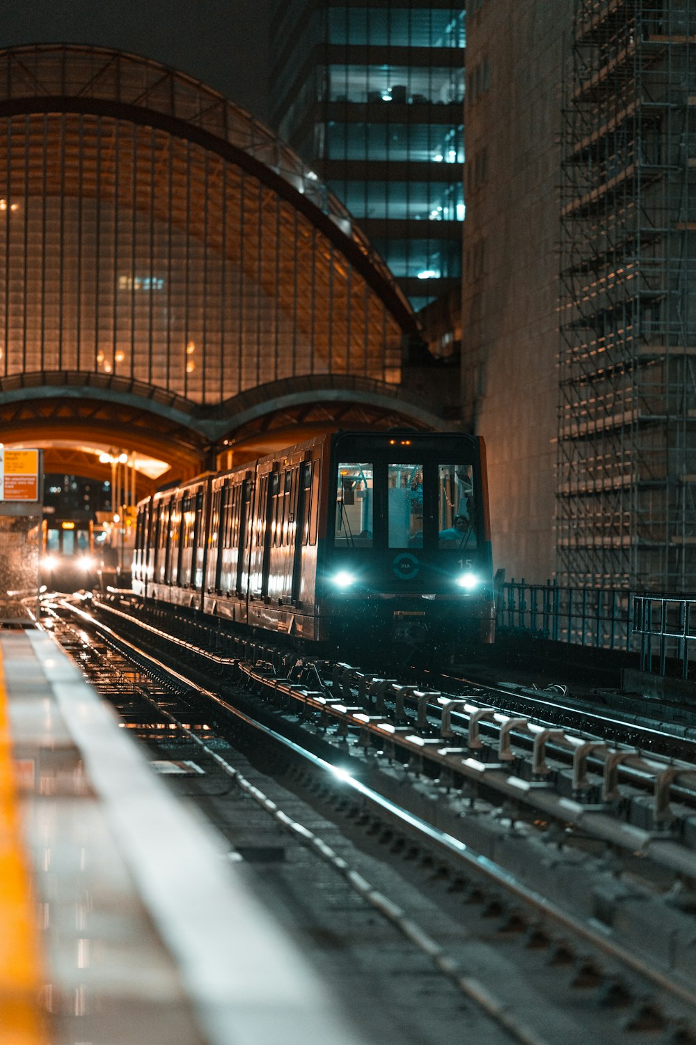 green train in the middle of the city during night time