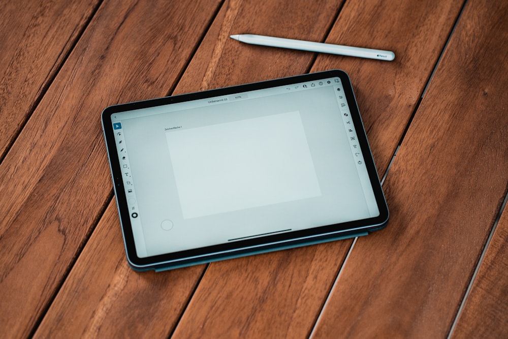 black ipad on brown wooden table